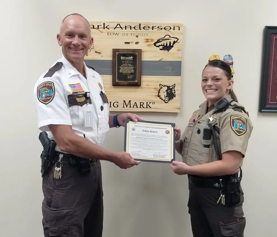 Sheriff Torgerson hands Deputy Howlett an award.