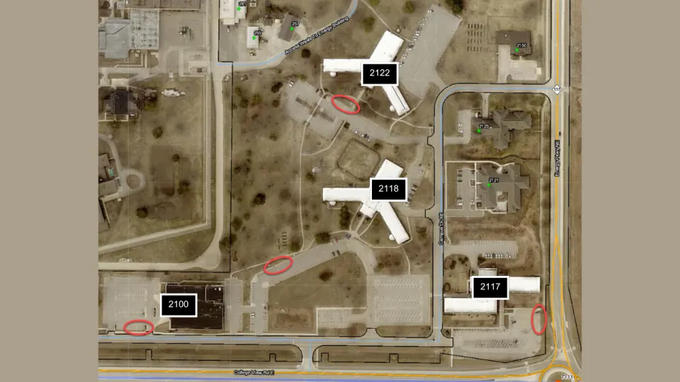 A map of Olmsted County campus buildings: 2100, 2117, 2118, and 2122. Red circles on the map indicate where EV charging stations will be located.