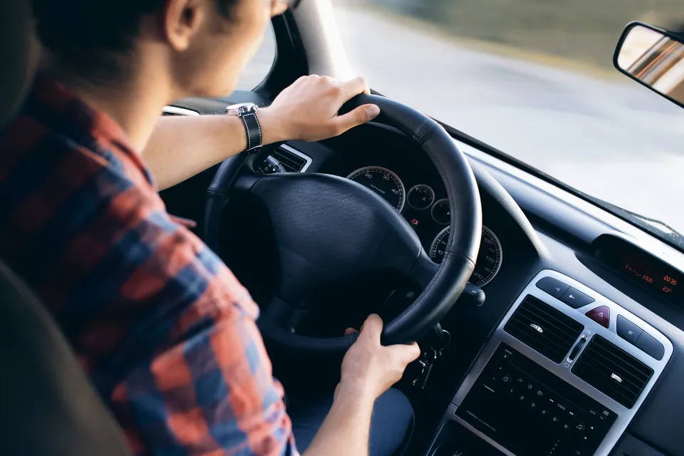 man driving, hand on steering wheel