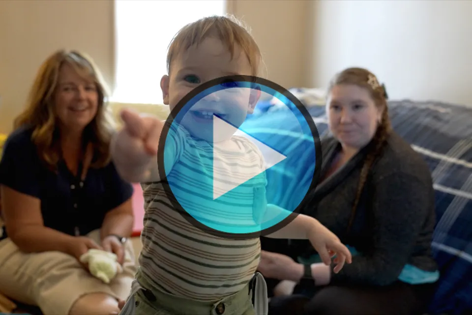 Video still of the Family Home Visiting program with a play button