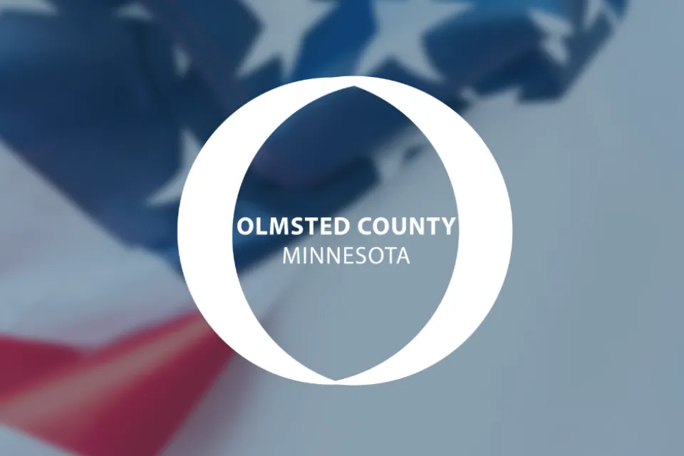 Olmsted County logo. An American flag draped in the background.